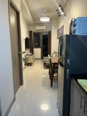 a kitchen with a refrigerator and a dining room at The Calm Corner - S Residences Tower 2 in Manila