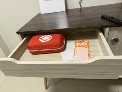 a drawer in a desk with a red purse and a book at The Calm Corner - S Residences Tower 2 in Manila