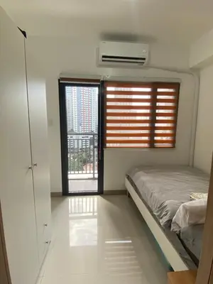 a bedroom with a bed and a window with a balcony at Calle Homes - 1BR unit with balcony, LUSH RESIDENCES in Manila