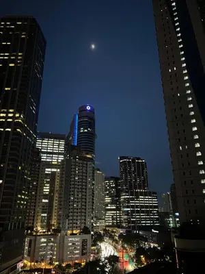 a view of a city at night with the moon at Calle Homes - 1BR unit with balcony, LUSH RESIDENCES in Manila