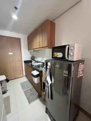 a kitchen with a stainless steel refrigerator with a microwave at Calle Homes - 1BR unit with balcony, LUSH RESIDENCES in Manila