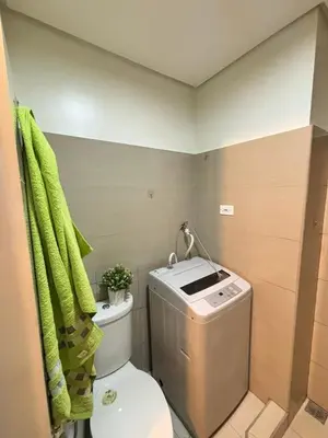 a bathroom with a toilet and a green towel at Twin Unit at Shore 2 Residences in Manila