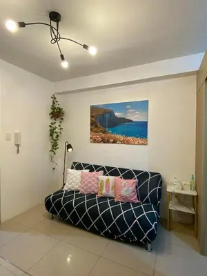 a living room with a couch and a painting on the wall at Haven's Suites a place like home in Manila