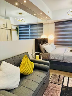 a living room with a couch and a bed at Sea Residences in Manila