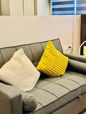 a yellow pillow sitting on top of a couch at Sea Residences in Manila