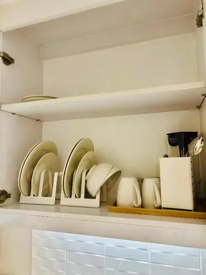 a kitchen shelf filled with plates and other dishes at Sea Residences in Manila
