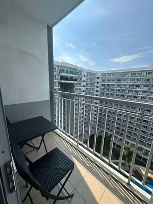 a balcony with a chair and a view of a building at Jeric Place Staycation in Manila