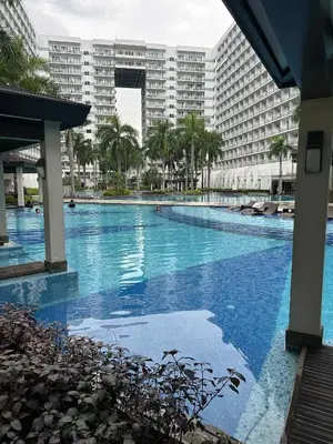 a large swimming pool in front of a large building at Jeric Place Staycation in Manila