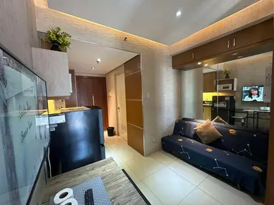 a living room with a couch and a kitchen at Jeric Place Staycation in Manila