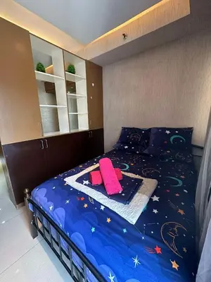 a bedroom with a bed with a blue comforter with stars at Jeric Place Staycation in Manila