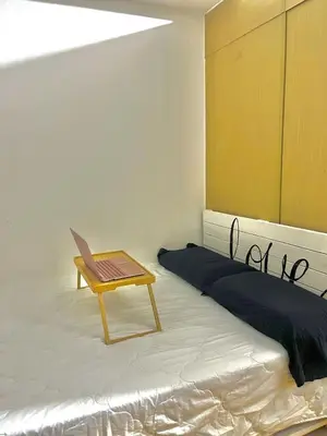 a room with a bed with a chair and a table at Taguig Condo Unit - Grace Residences by Jenn in Manila