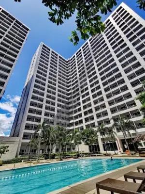 a large building with a swimming pool in front of it at Taguig Condo Unit - Grace Residences by Jenn in Manila