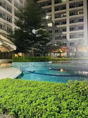a swimming pool in front of a large building at Taguig Condo Unit - Grace Residences by Jenn in Manila