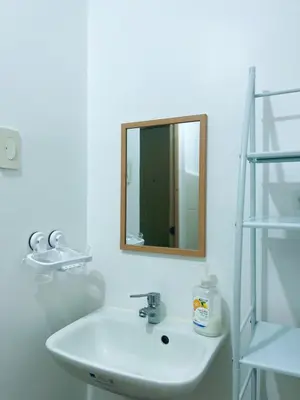 a white bathroom with a sink and a mirror at Taguig Condo Unit - Grace Residences by Jenn in Manila