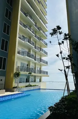 a swimming pool in front of a building at The Bloom by Y&Y Condo at Bayshore Res Resort in Manila