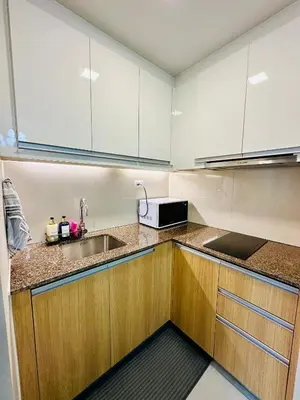 a kitchen with white cabinets and a sink and a microwave at The Bloom by Y&Y Condo at Bayshore Res Resort in Manila