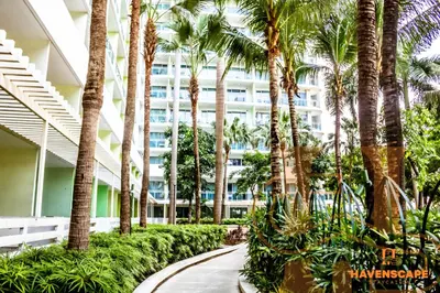 a walkway in front of a building with palm trees at Havenscape Staycation in Manila