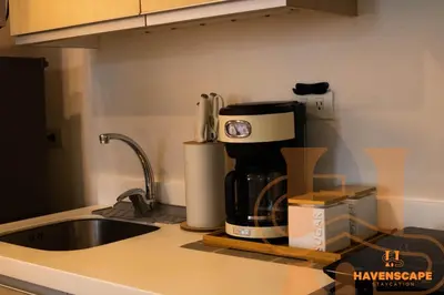 a kitchen counter with a coffee maker on a counter top at Havenscape Staycation in Manila
