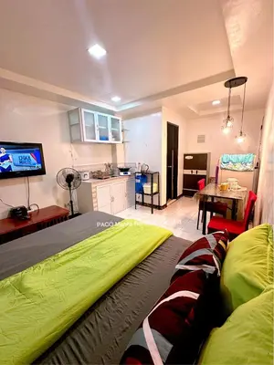 a bedroom with a bed and a kitchen with a tv at Paco Manila Rental Studio Unit in Manila