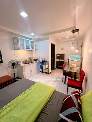 a bedroom with a bed and a table and a kitchen at Paco Manila Rental Studio Unit in Manila