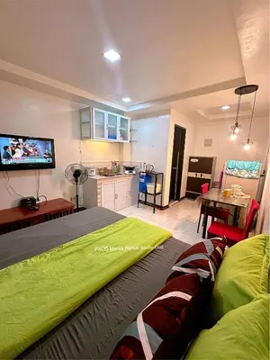 a bedroom with a bed and a kitchen with a tv at Paco Manila Rental Studio Unit in Manila