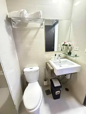 a bathroom with a white toilet and a sink at Aura Zen Suites condotel in Manila