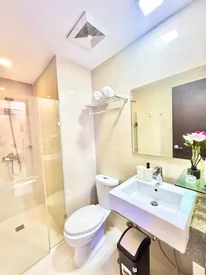 a bathroom with a toilet and a sink and a shower at Aura Zen Suites condotel in Manila