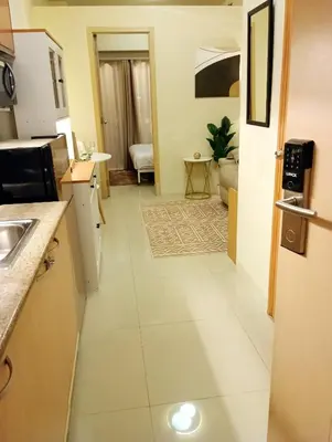 a room with a kitchen and a living room at Lovers' Cozy 1BR Condo Near Mall and Airport with Free Netflix Premium and 100 MBPS WiFi in Manila