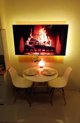 a table with chairs and a fireplace in a room at Lovers' Cozy 1BR Condo Near Mall and Airport with Free Netflix Premium and 100 MBPS WiFi in Manila