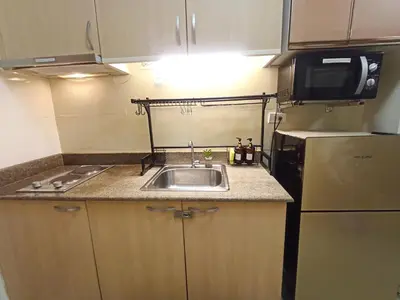 a small kitchen with a sink and a refrigerator at Lovers' Cozy 1BR Condo Near Mall and Airport with Free Netflix Premium and 100 MBPS WiFi in Manila