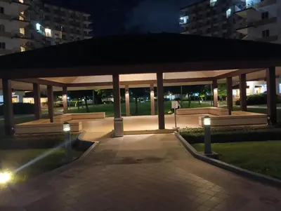 a gazebo with benches in a park at night at Lovers' Cozy 1BR Condo Near Mall and Airport with Free Netflix Premium and 100 MBPS WiFi in Manila