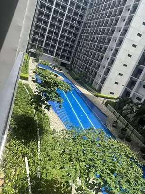 a swimming pool in front of a tall building at Don Comz Staycation in Manila