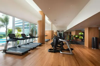 a gym with a row of treadmills and exercise equipment at Conrad Manila in Manila