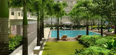 a swimming pool with palm trees in front of a building at Deck&Dwell in Trece Martires