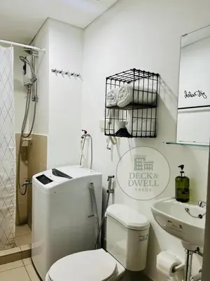 a white bathroom with a toilet and a sink at Deck&Dwell in Trece Martires