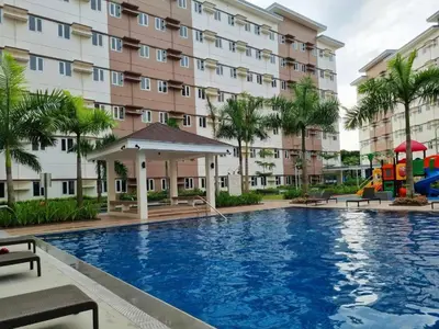 a large swimming pool in front of a building at Deck&Dwell in Trece Martires