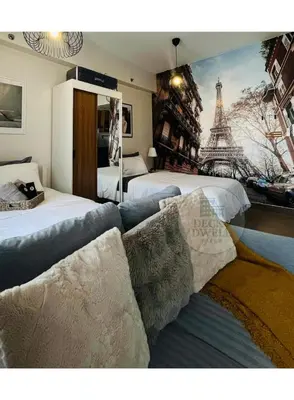 a bedroom with two beds and a mural of the eiffel tower at Deck&Dwell in Trece Martires