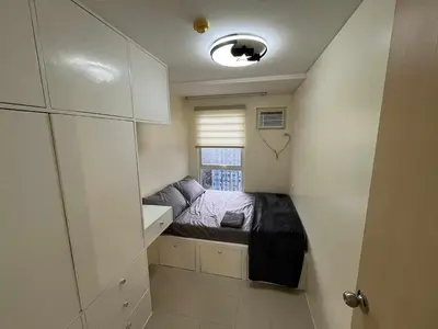 a small room with a bed and a window at Enzo vibes in Manila