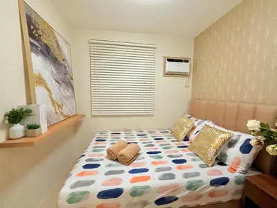 a bedroom with a bed with a comforter and pillows at 1-Bedroom Cozy Haven Sorrento Oasis in Manila