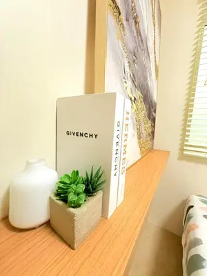 a book sitting on a shelf next to a plant at 1-Bedroom Cozy Haven Sorrento Oasis in Manila