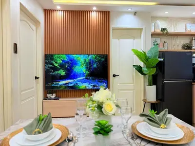 a dining room with a table and a television at 2-Bedroom Cozy Haven Sorrento Oasis in Manila
