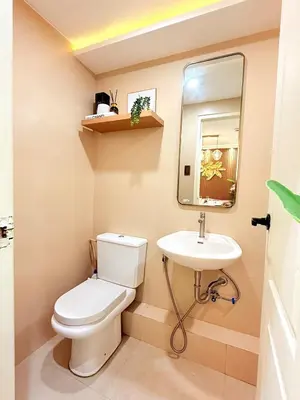 a small bathroom with a toilet and a sink at 2-Bedroom Cozy Haven Sorrento Oasis in Manila