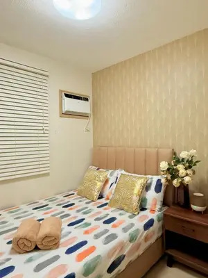 a bedroom with a bed with two pillows at 2-Bedroom Cozy Haven Sorrento Oasis in Manila