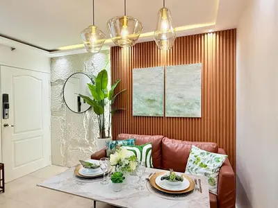 a dining room with a table and a pink couch at 2-Bedroom Cozy Haven Sorrento Oasis in Manila