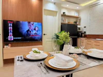 a dining table with plates and a tv in a kitchen at 2-Bedroom Cozy Haven Sorrento Oasis in Manila