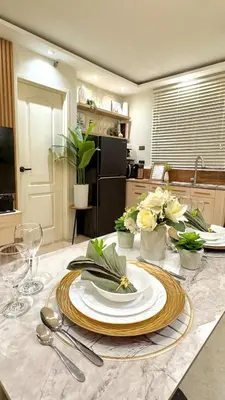 a table with a plate of food on top of it at 2-Bedroom Cozy Haven Sorrento Oasis in Manila