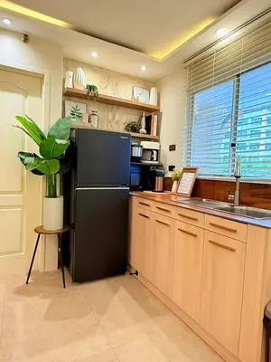 a kitchen with a black refrigerator and a sink at 2-Bedroom Cozy Haven Sorrento Oasis in Manila