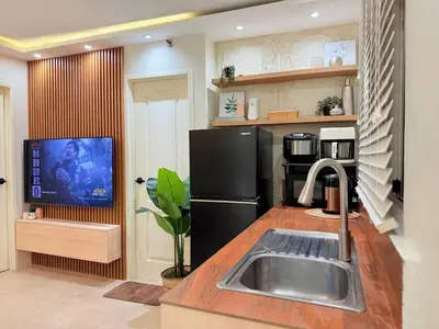 a kitchen with a sink and a black refrigerator at 2-Bedroom Cozy Haven Sorrento Oasis in Manila