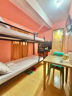 a room with two bunk beds and a table at Solano Transient House in Manila