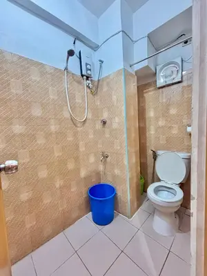 a bathroom with a shower with a toilet and a bucket at Solano Transient House in Manila